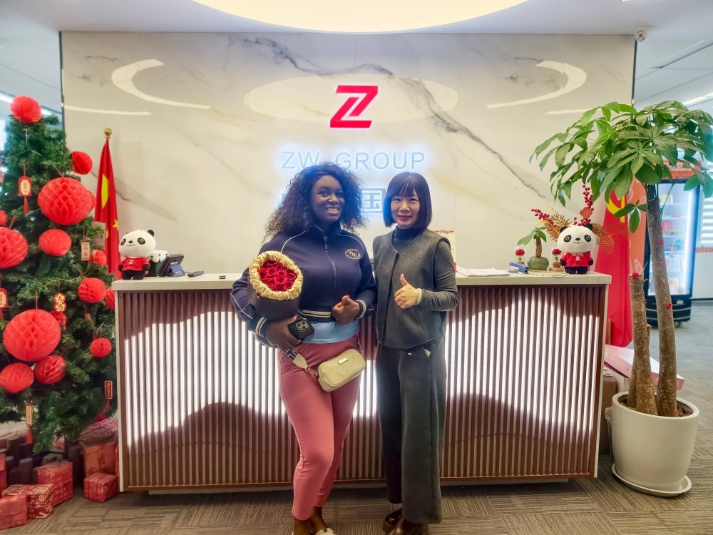 Cindy with Ghana client at ZW Group factory entrance discussing fuel tanker trailer purchase