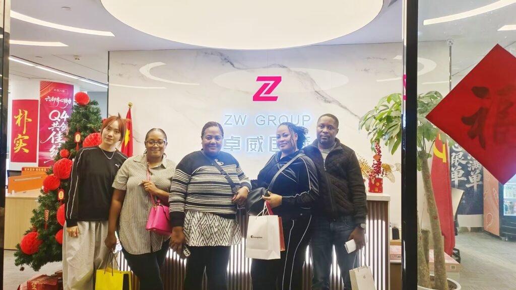 ZW Group team with four Zambia clients at company gate during fuel tanker trailer solution discussion for mining logistics