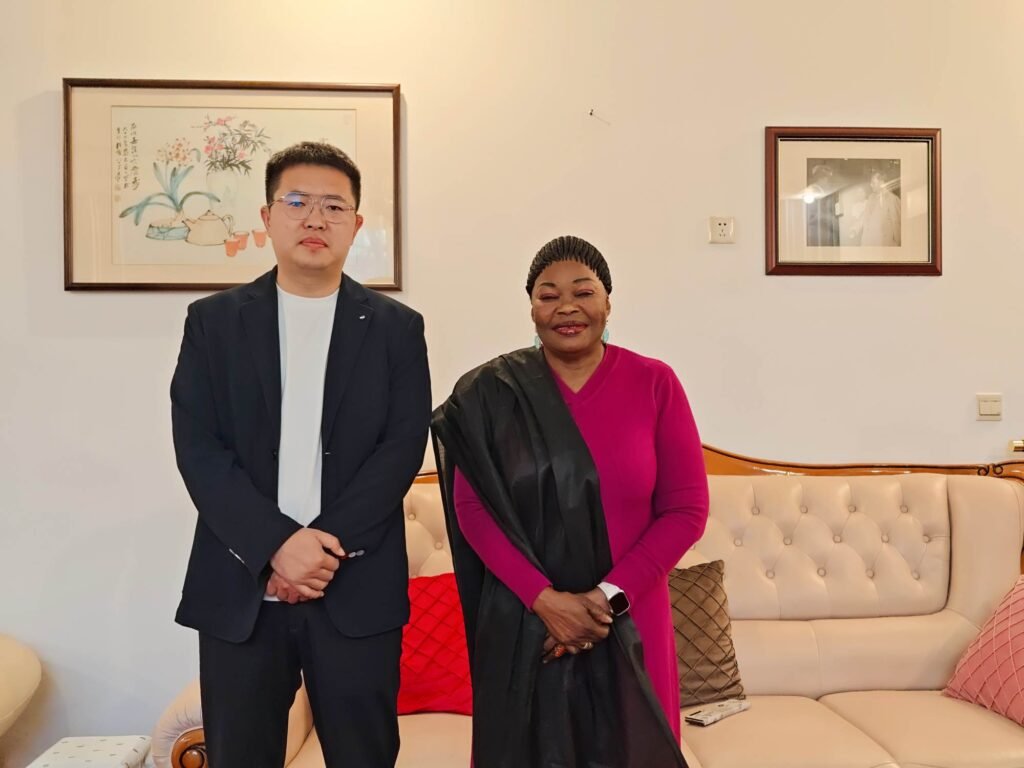 Chairman Ivan Sun (Sun Yongchang) with Guinean Ambassador Aminata Koita formalizing energy transport cooperation.