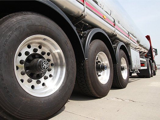 Inspecting tank trailer tires wear and BPW axles on a stainless steel fuel tanker semi trailer